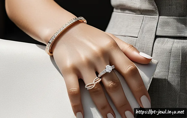 로즈골드 vs 화이트골드 비교 - A close-up image of a sophisticated woman&rsquo;s hand adorned with elegant white gold jewelry, including ...